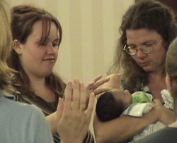 Terri Palmquist holds baby Andrew at the prayer watch as his mom Jessica looks on