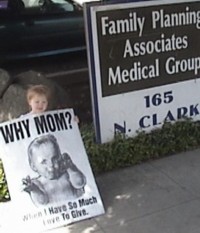 Sarah Palmquist holding sign 'Why Mom? When I have so much love to give' outside Fresno FPA abortion chamber