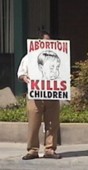 LSM volunteer holds sign near Fresno FPA abortion chamber