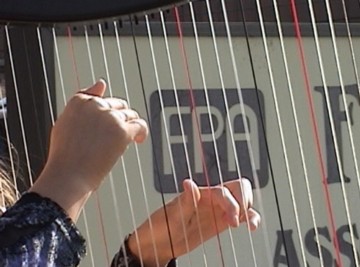 FPA abortion chamber sign seen through harpist's strings